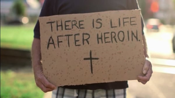Formerly homeless man holds sigh "There is life after heroin."